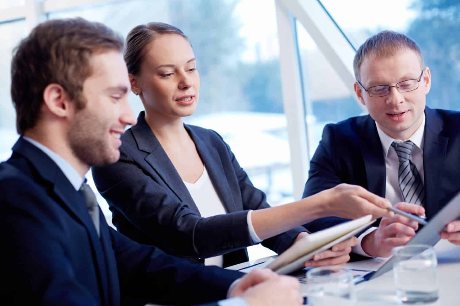 Business people looking at a tablet and discussing content.
