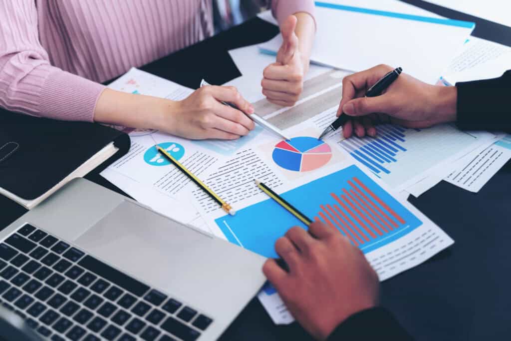 Hands pointing to charts on a table