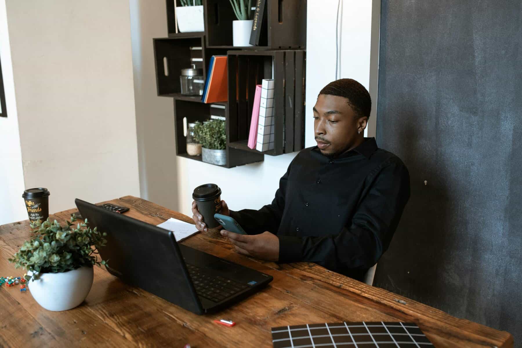 Man in Black Dress Shirt Sitting on Chair in Front of Laptop Computer