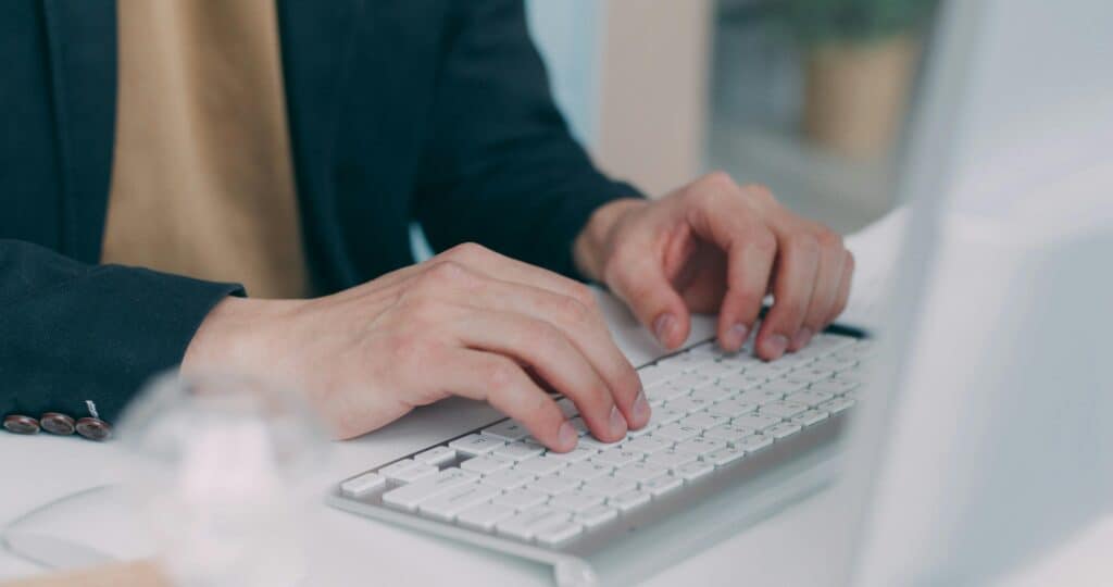 Fractional CFO hands typing on white keyboard